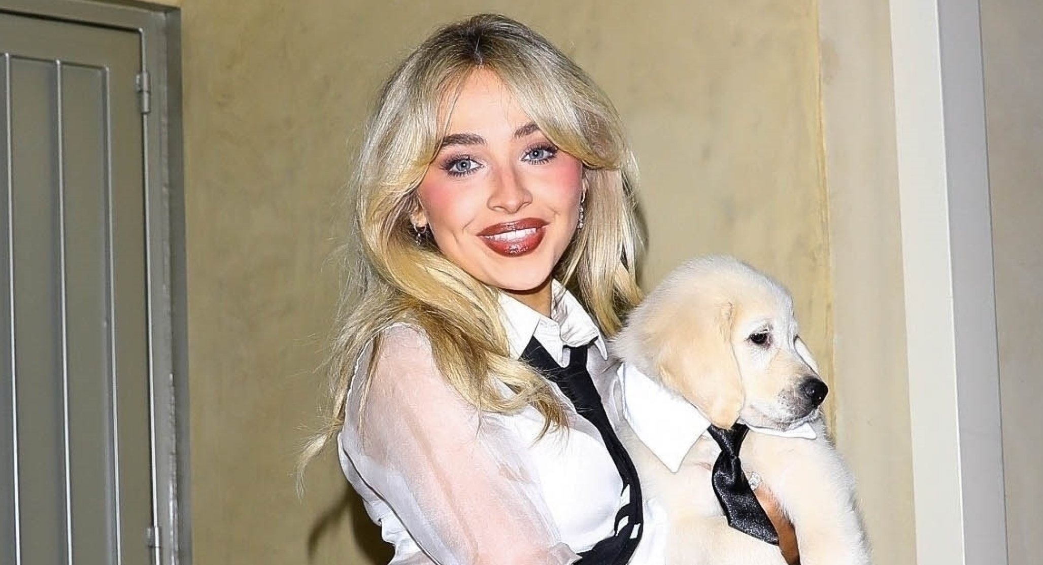 Sabrina Carpenter carries a puppy while wearing Thom Browne