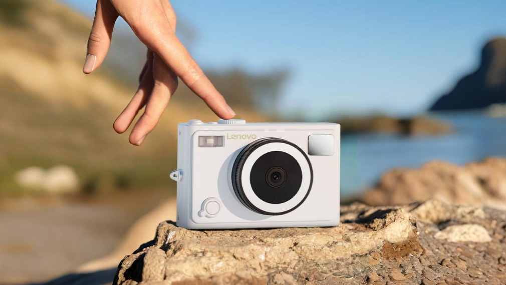 Lenovo C55 lifestyle image of camera on rocks in front of landscape with hand touching mode dial 