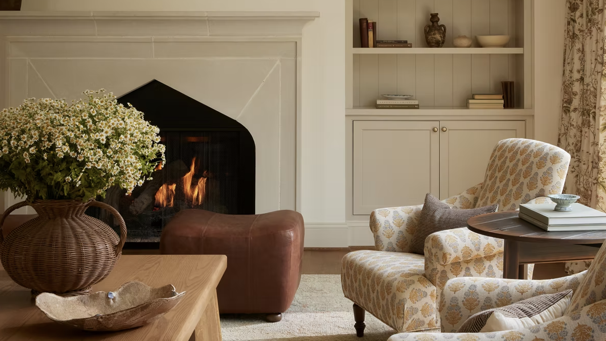 neutral living room with roaring open fire and patterned armchairs