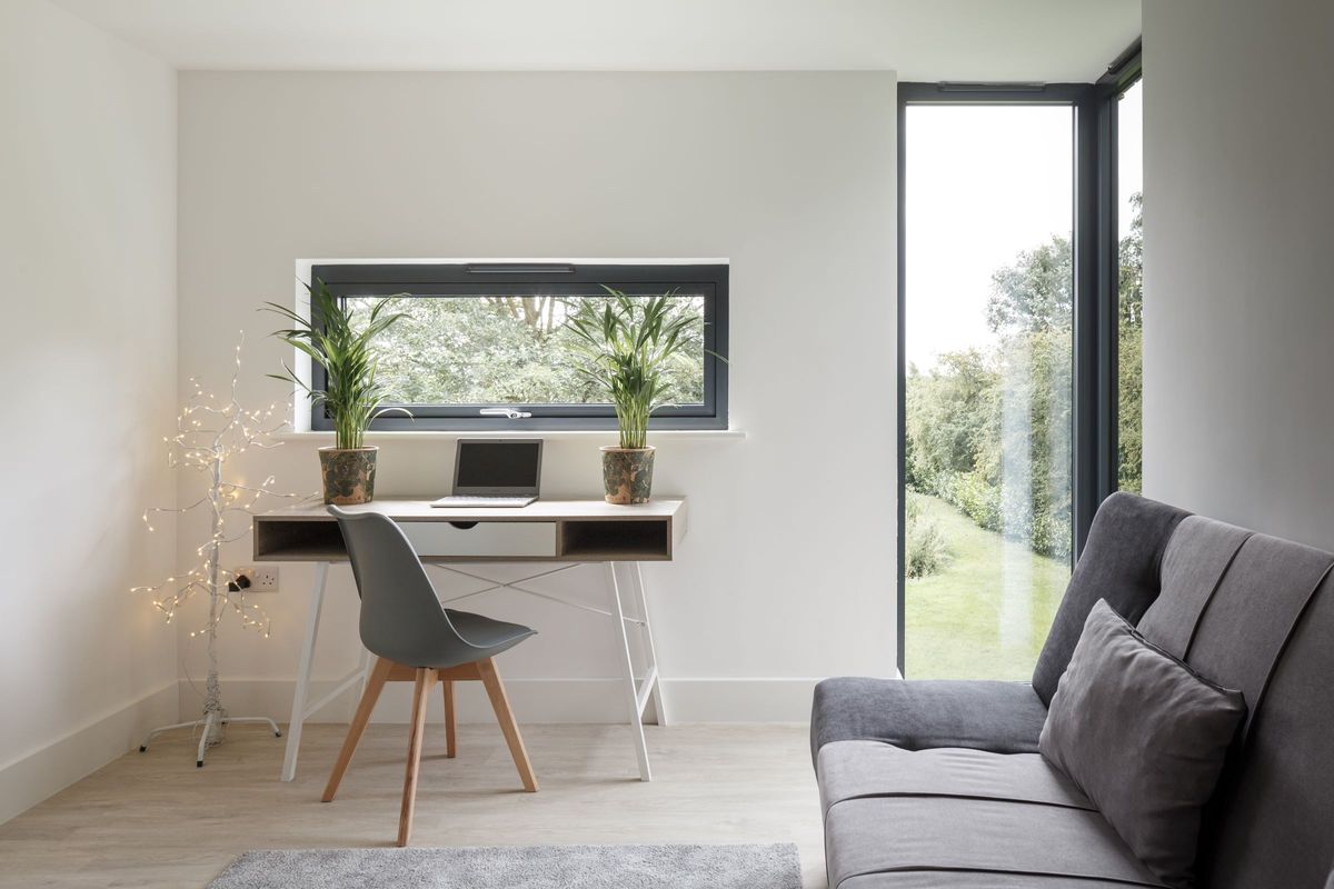 An office with sofa and large corner window