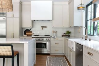 Kitchen with light coffee and cream painted cabinets and white marble island.