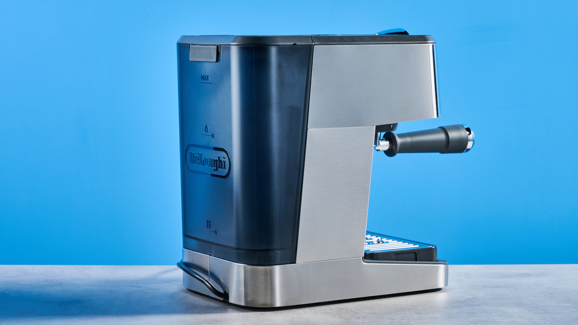 the De'Longhi Linea Classic espresso machine photographed against a blue tom's guide background, showing its silver finish, steam dial, steam wand, portafilter, and accessories