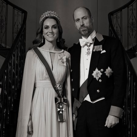 A black and white photo of Princess Kate and Prince William on a staircase in formalwear 