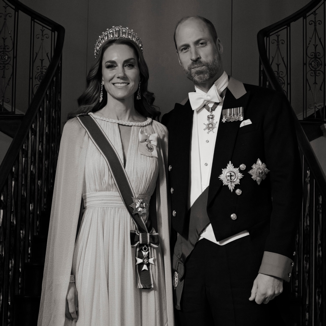 A black and white photo of Princess Kate and Prince William on a staircase in formalwear 