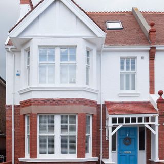 End of terrace Edwardian house exterior with blue door
