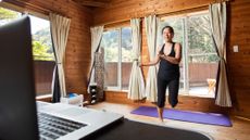 Woman exercising in front of a laptop at home