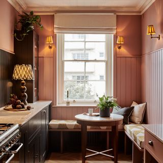 banquette seating at the end of a plaster pink galley kitchen neptune