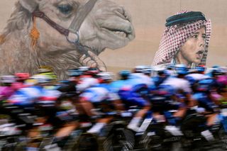 ABU DHABI UNITED ARAB EMIRATES FEBRUARY 21 A general view of the peloton competing with graffiti in the background during the 4th UAE Tour 2022 Stage 2 a 176km stage from Hudayriyat Island to Abu Dhabi Breakwater UAETour WorldTour on February 21 2022 in Abu Dhabi United Arab Emirates Photo by Tim de WaeleGetty Images