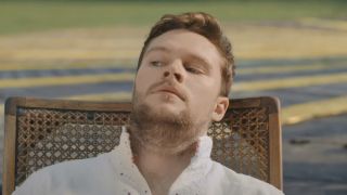 Jack Reynor as Christian in a chair in Midsommar