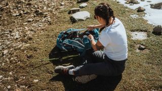 Writer Sam sitting during hike in the Alps wearing the Columbia Facet 75 Alpha hiking shoe