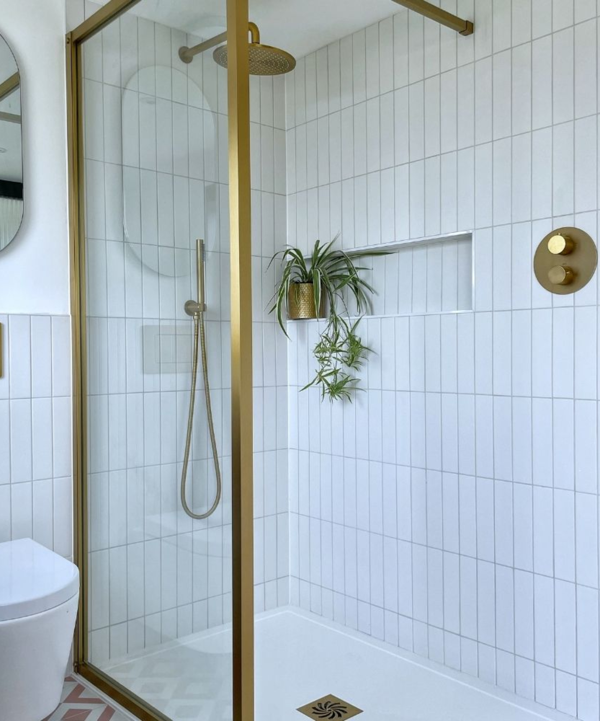 gold framed shower screen with recessed shelf in wall