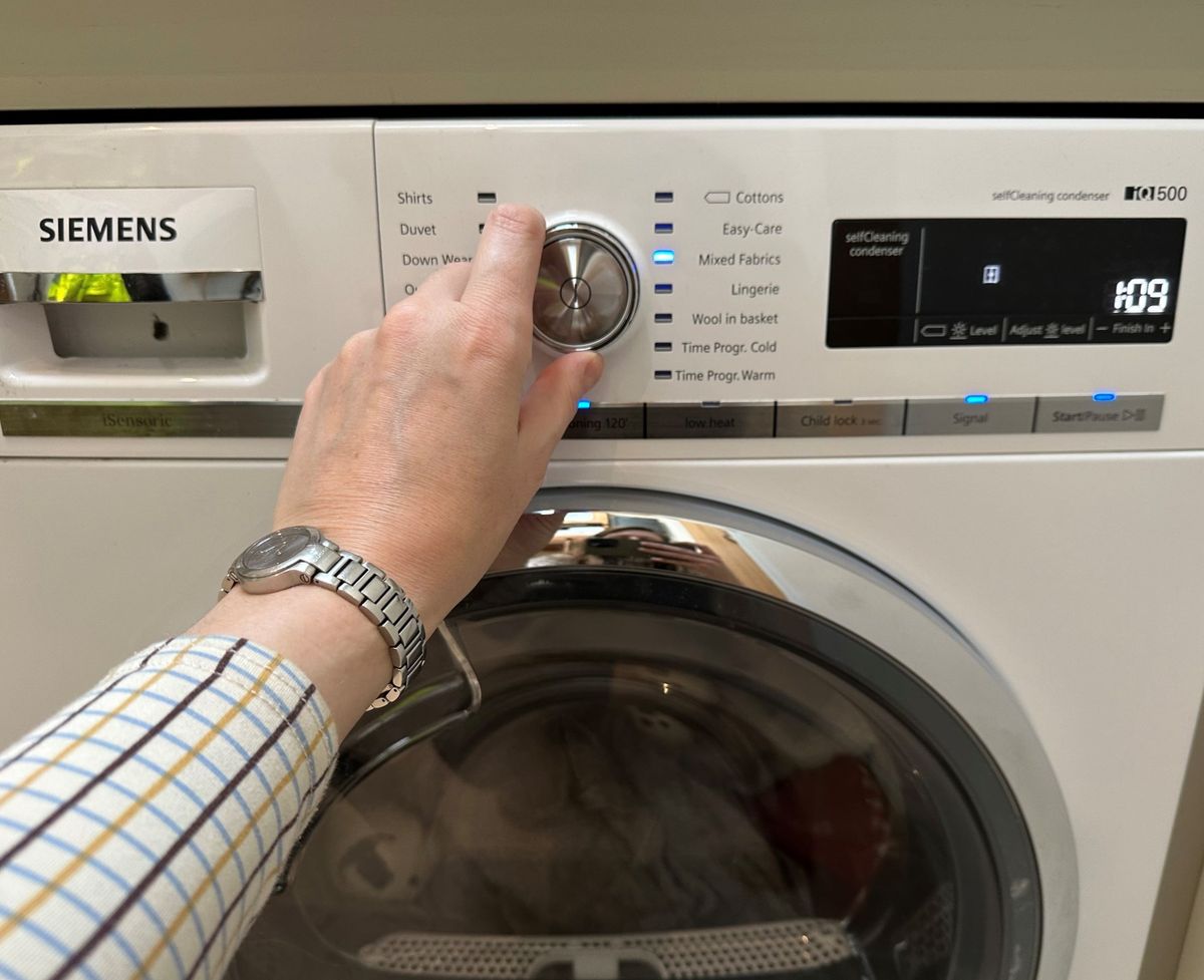 Pressing the dials of the Siemens heat pump tumble dryer to select the drying cycle