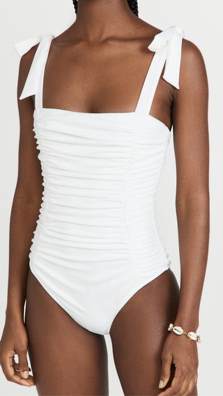 The model wore a white ruffled one-piece swimsuit