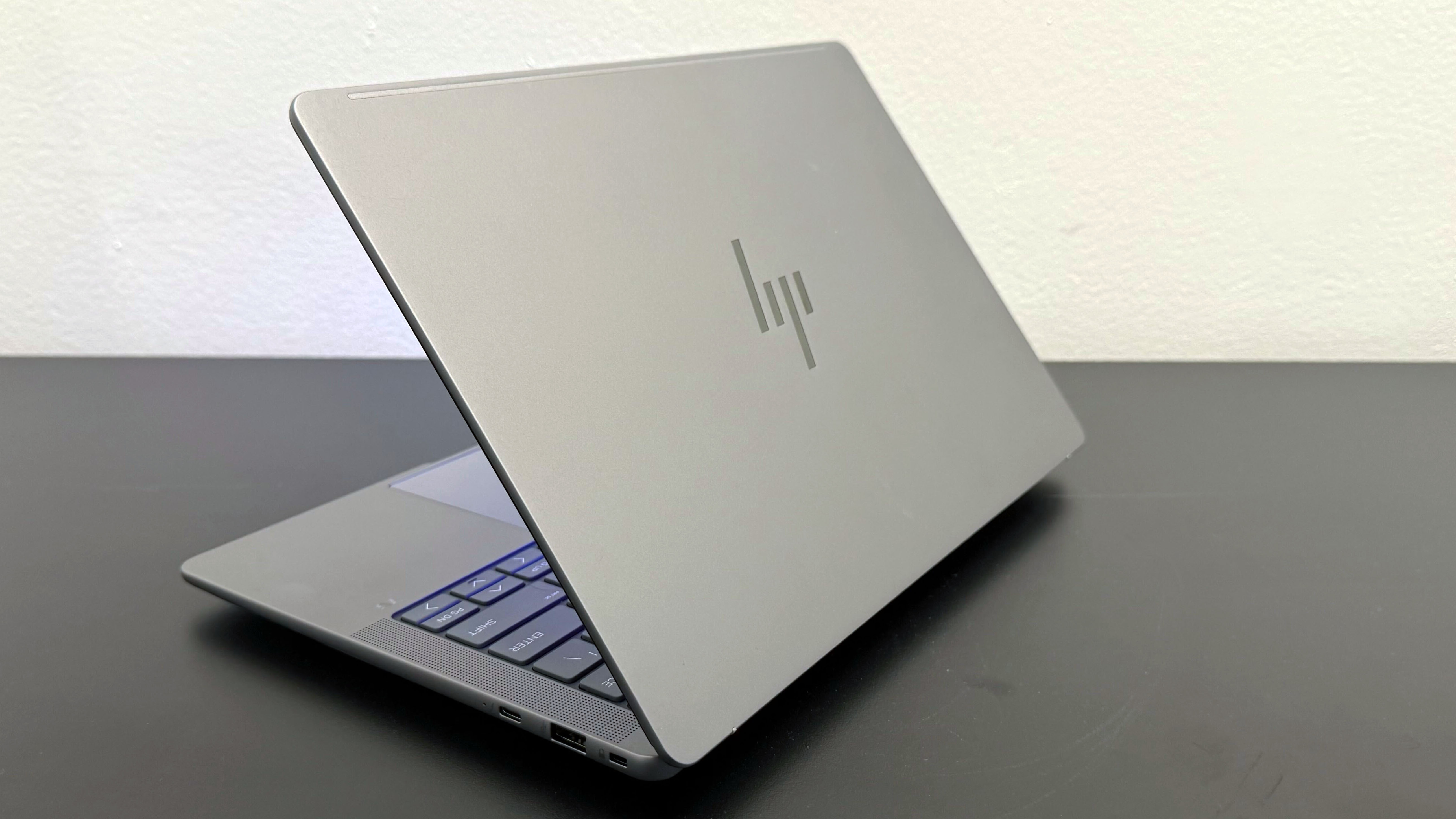 The HP ZBook Ultra 14 G1a mobile workstation facing away on a black desk against a white wall.