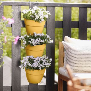 hanging pots on fencing by patio seats