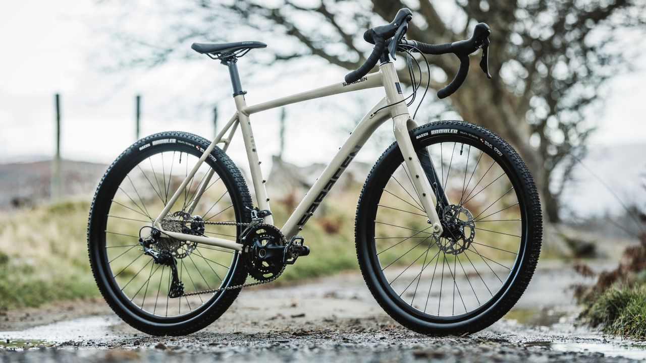 The Saracen Levarg SL pictured in full on a muddy road with trees and fields blurred in the background 