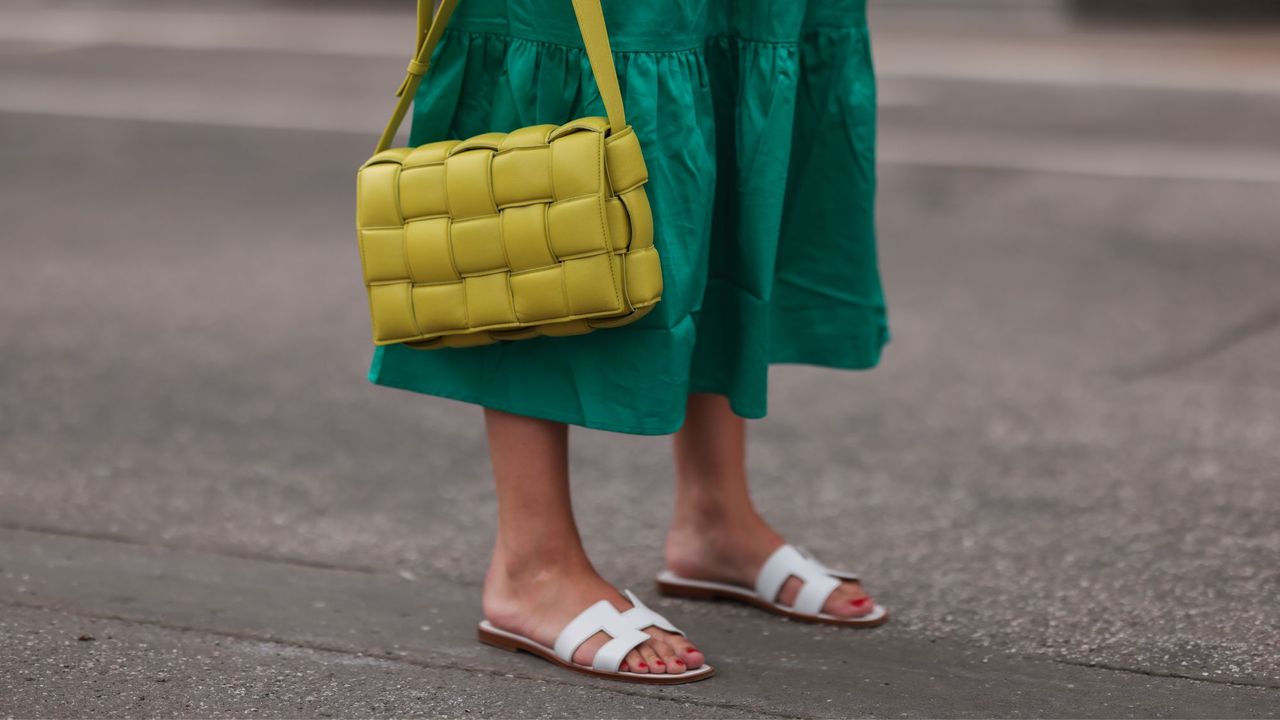 a woman posing in Hermès Oran sandals