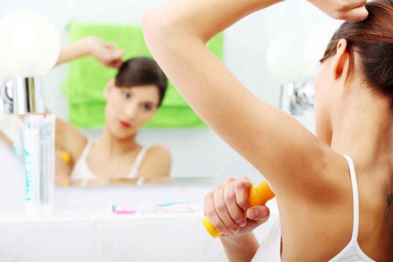 woman putting deodorant on