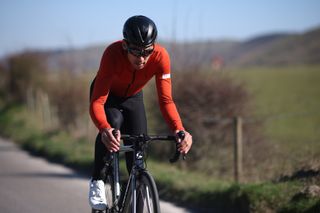 Image shows a person cycling outdoors.
