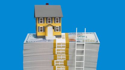 A small model home on top of a stack of $100 bundles. With a tiny ladder on the right side.