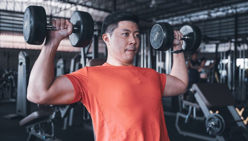 Man performing dumbbell shoulder press