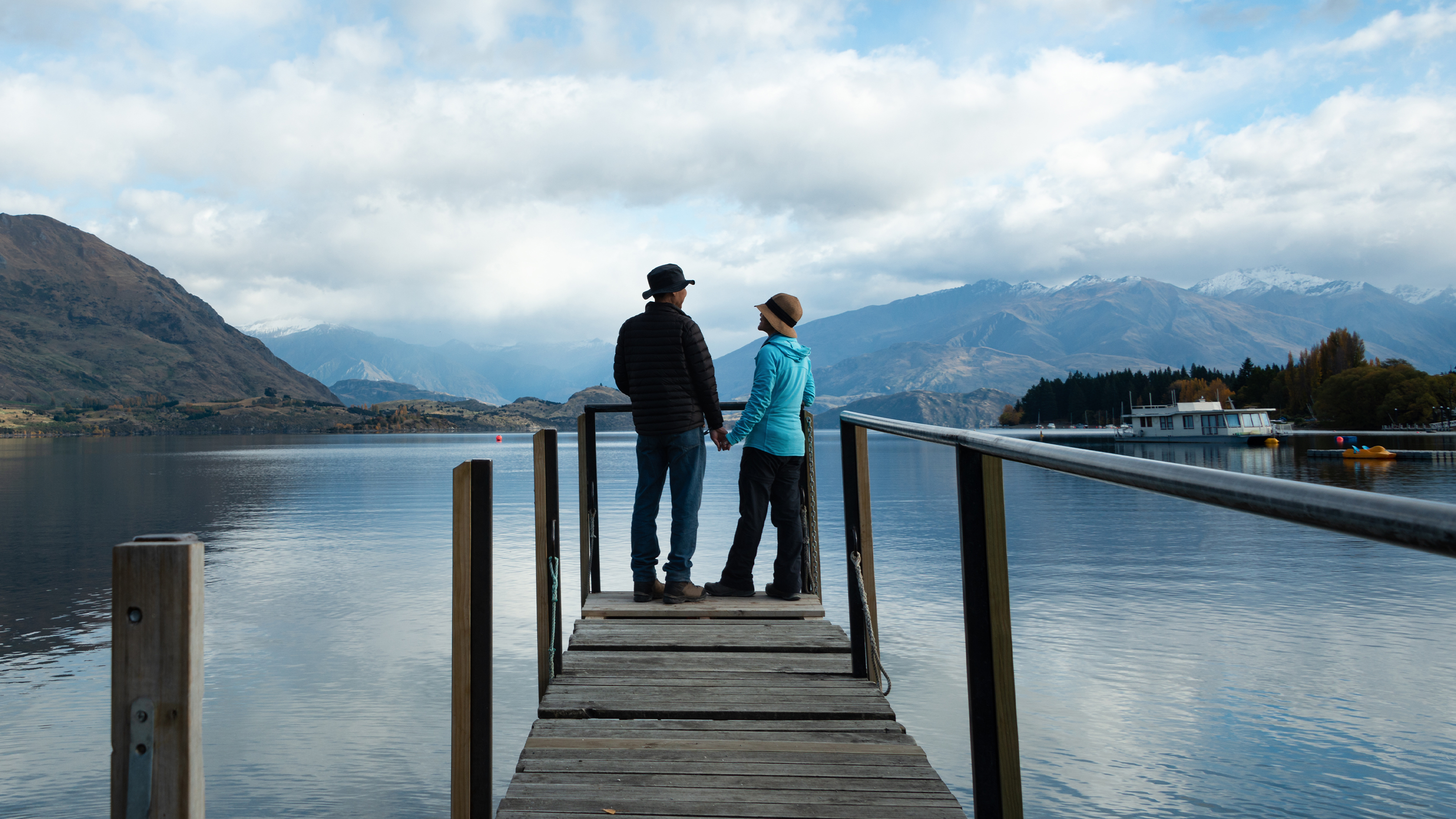 Two people standing on the end of a dock