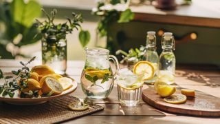 table with jug and glasses of iced lemon water