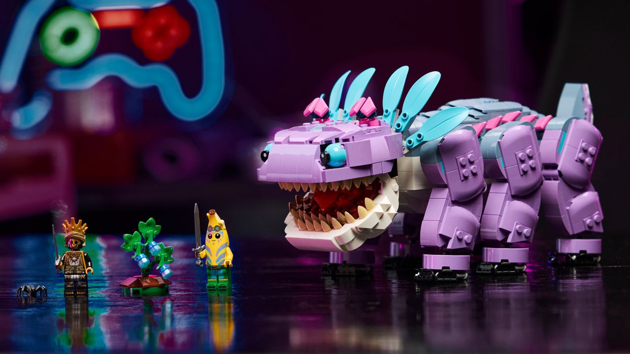 Lego Klombo alongside two minifigures and a Lego bush, with a neon controller in the background