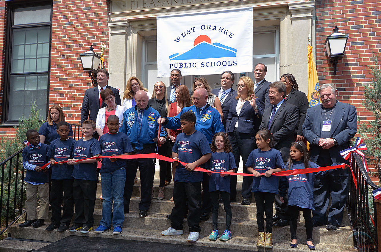 Astronauts Mark and Scott Kelly join students and school officials cutting a ribbon marking the opening of the newly-renamed Kelly Elementary School in West Orange, New Jersey, May 19, 2016. 