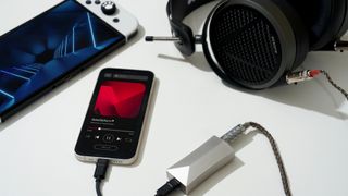 Astell & Kern HC4 DAC alongside headphones, a mobile player and a games console