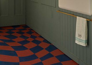 blue and red painted laundry room flooring with green cabinets.