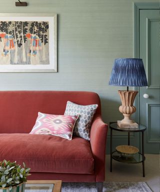 Living room with pale green walls and a rust sofa