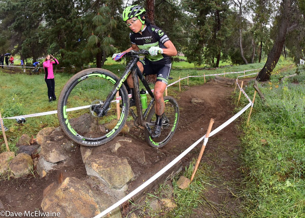 Evelyn Dong (Cannondale) muscling her bike over some boulders