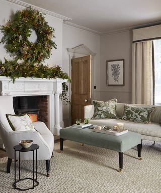 Christmas fireplace decor with a large foliage wreath and garland on and above the mantel