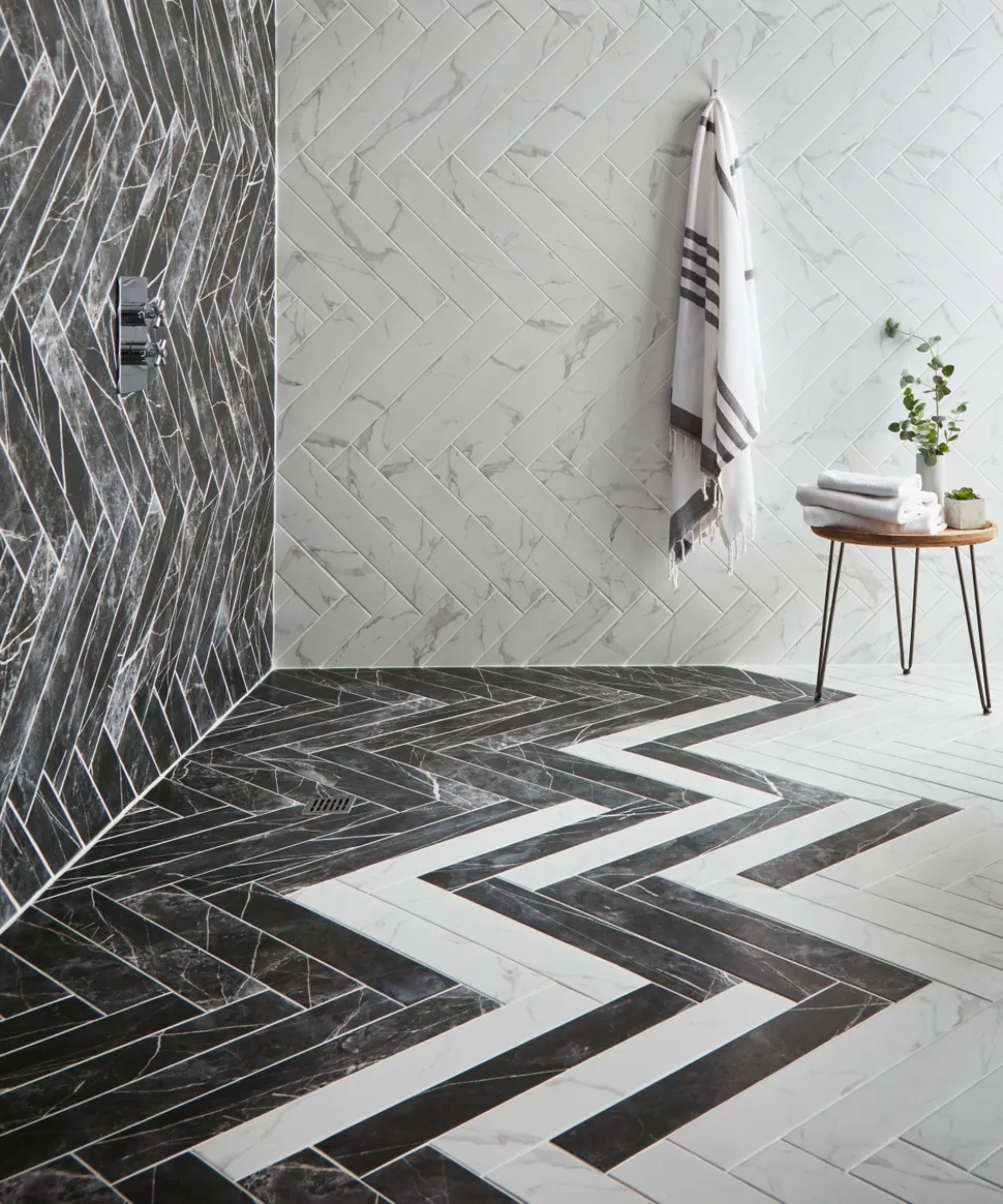 black and white bathroom tiles laid in a pattern in a small shower room