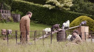 Samuel West as Siegfried and James Anthony-Rose as Carmody in brown vets' coats tend to some pygmy goats in All Creatures Great and Small.