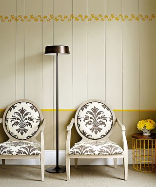 Panelling ideas for walls with yellow painted panelling and armchairs