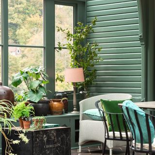 Farrow & Ball Green Smoke No.47 in a garden conservatory room with a large glass window