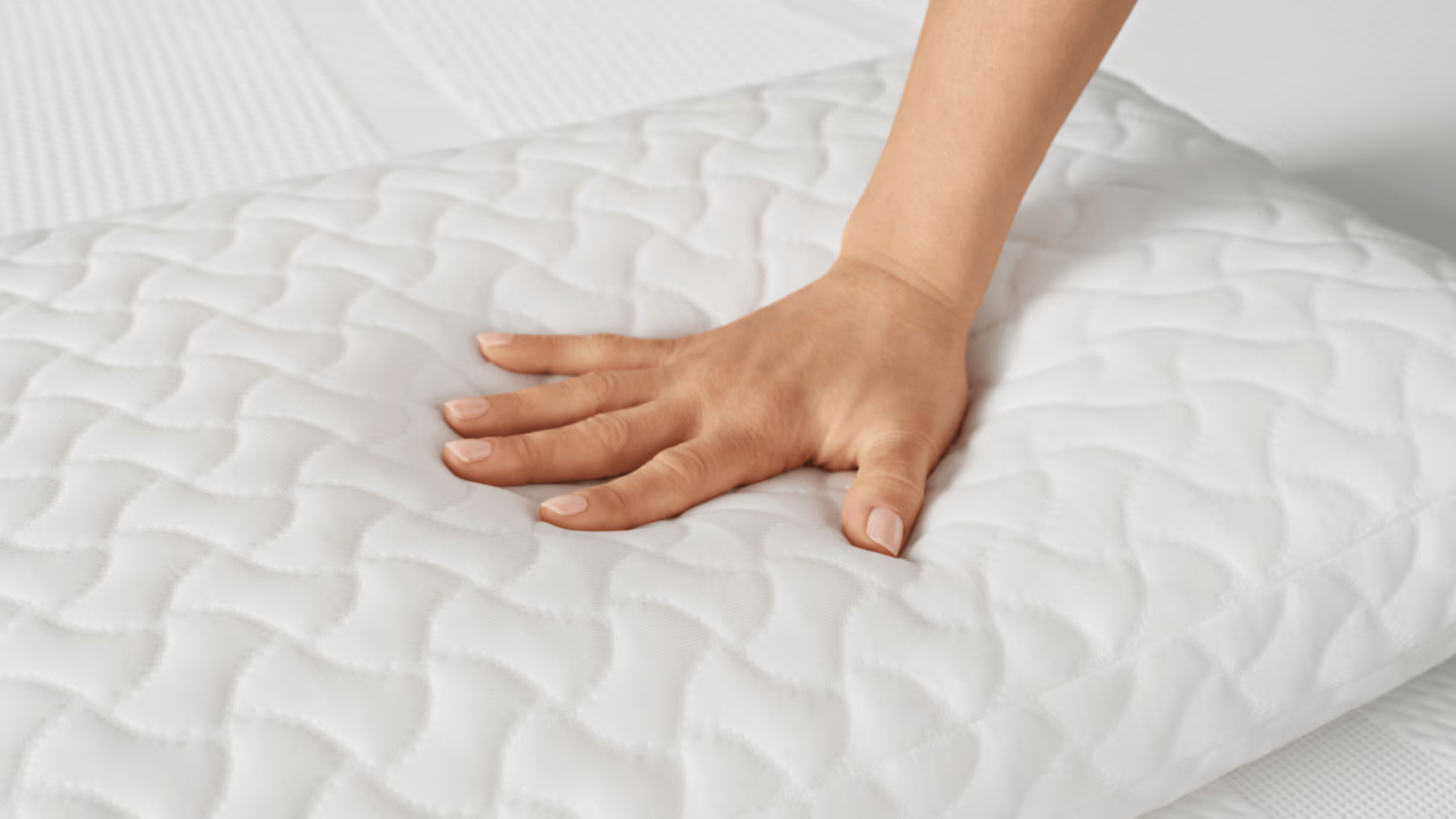 Hand placed on a white Tempur-Pedic Cloud pillow