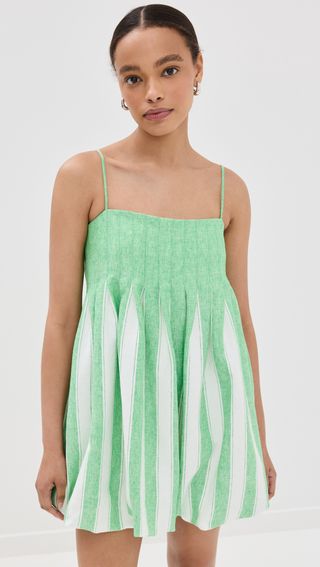 Model is wearing a green and white sleeveless bubble hem dress