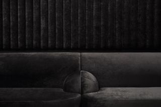 Black velvet textured conjoined seating, black textured, ribbed effect backdrop