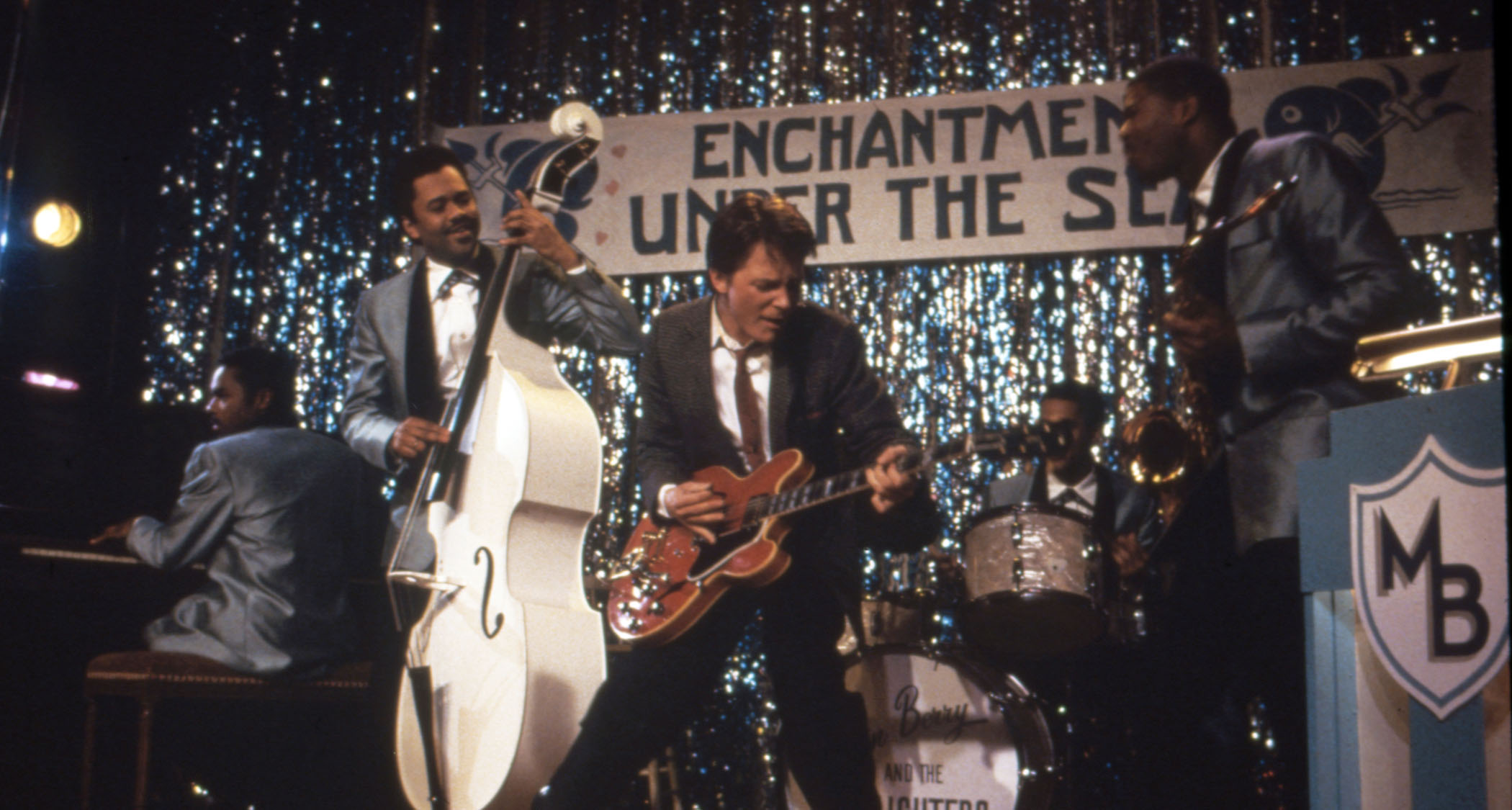 A still from Back to the Future&#039;s Enchantment Under the Sea Dance where Marty McFly performs Johnny B. Goode on a red Gibson ES-345.
