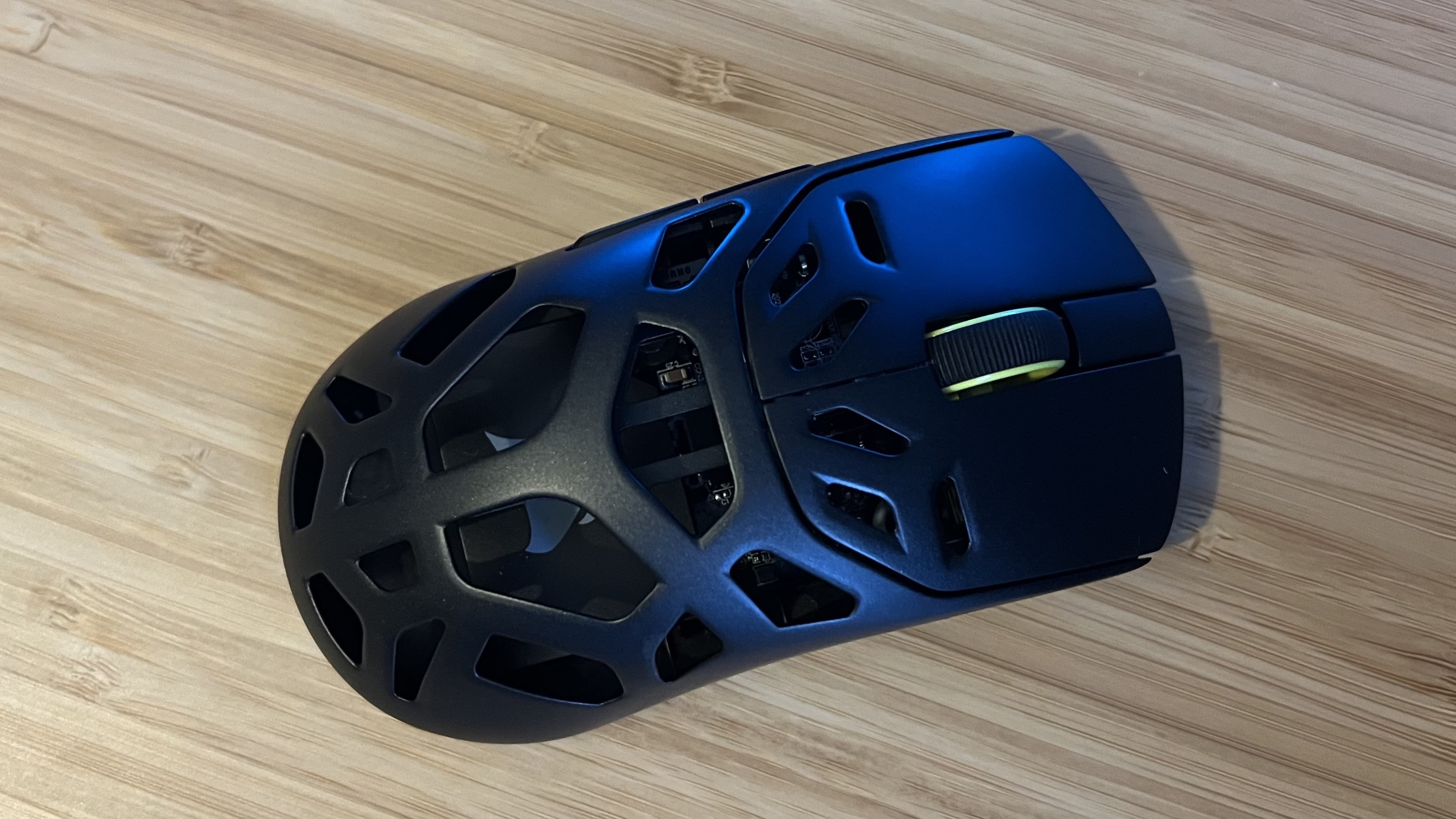 Top down view of Corsair Sabre V2 Pro Wireless MG gaming mouse on a wooden desk