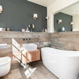 bathroom with the mirror on one wall including white bathtub