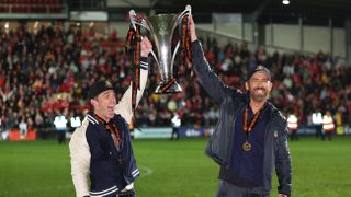 Rob McElhenney and Ryan Reynolds raising the Vanarama National League Trophy on April 22, 2023 to celebrate Wrexham's promotion to the English Football League