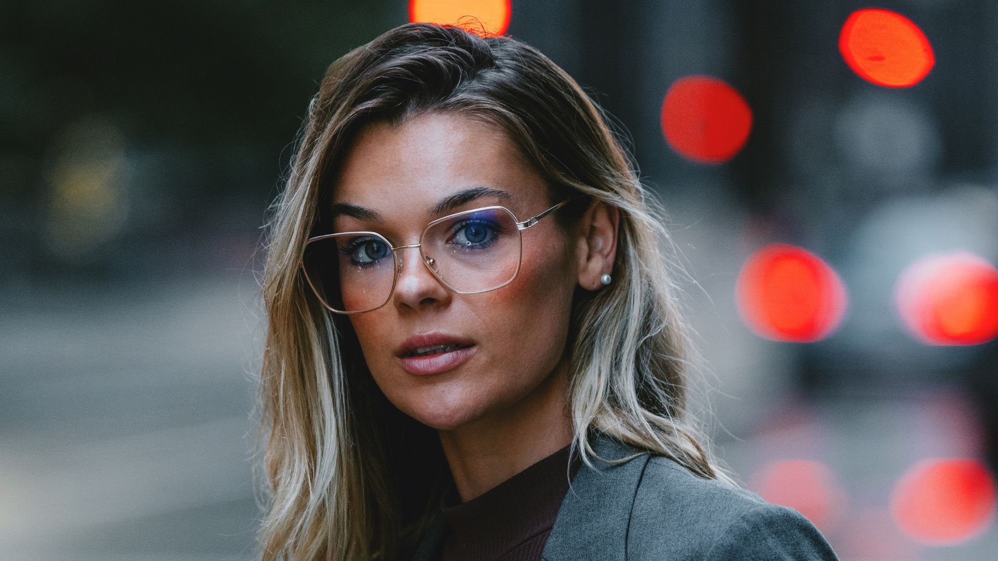 woman wearing glasses with blonde hair with a highlighting blush on her cheekbones - mac beam blush review