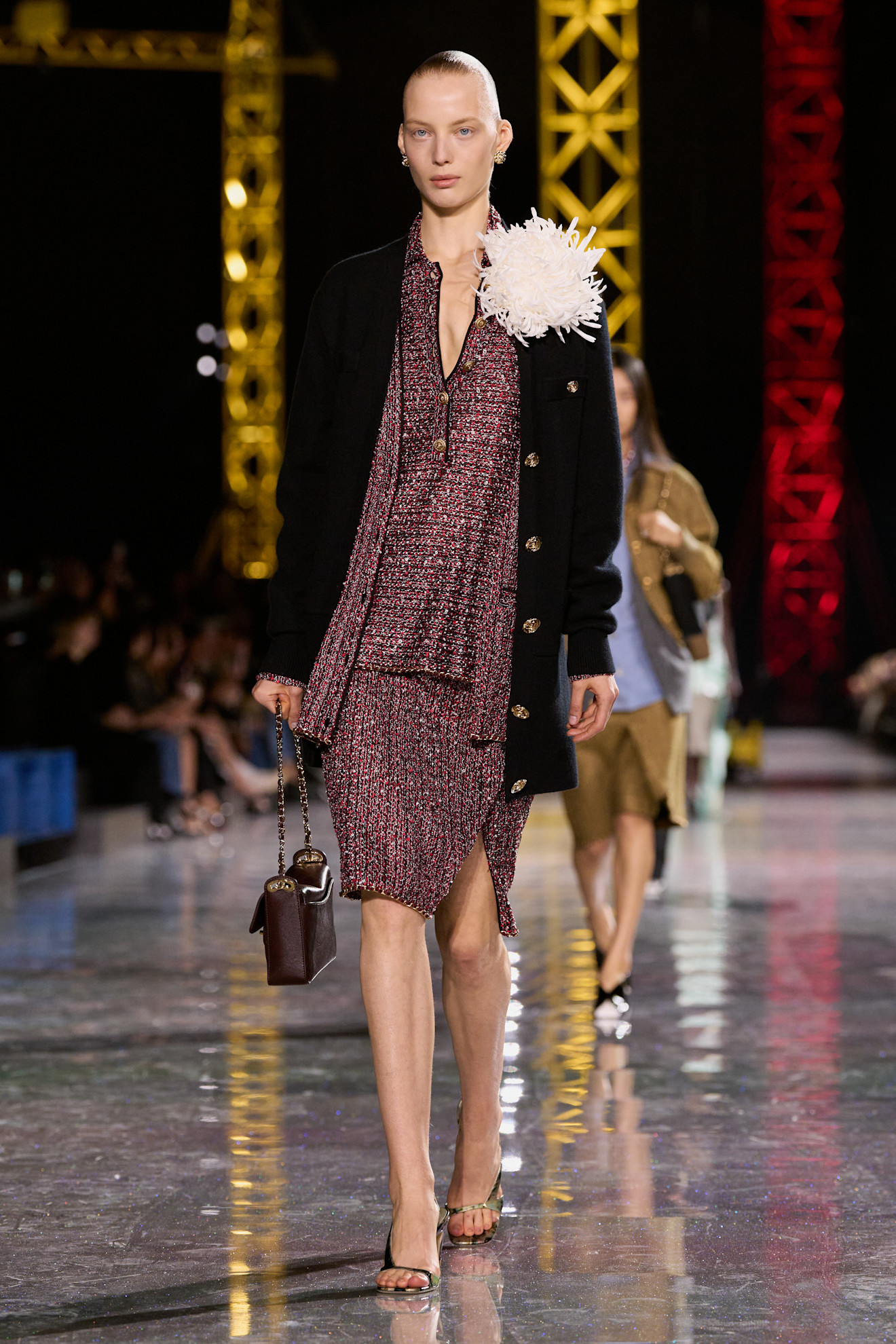 Copenhagen Fashion Week attendee wears an oversized feathery brooch with a jumper and shorts.