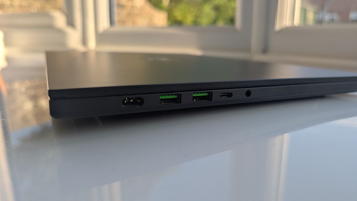 The Razer Blade 16 photographed for TechRadar on a white surface with plants in the background.