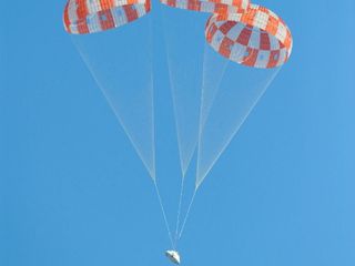 A model of NASA’s Orion spacecraft glides to a successful touchdown during a test of its parachute system on May 1, 2013. Orion's three main parachutes, which gradually slow the capsule for landing, weigh 300 pounds each and can cover almost an entire football field.