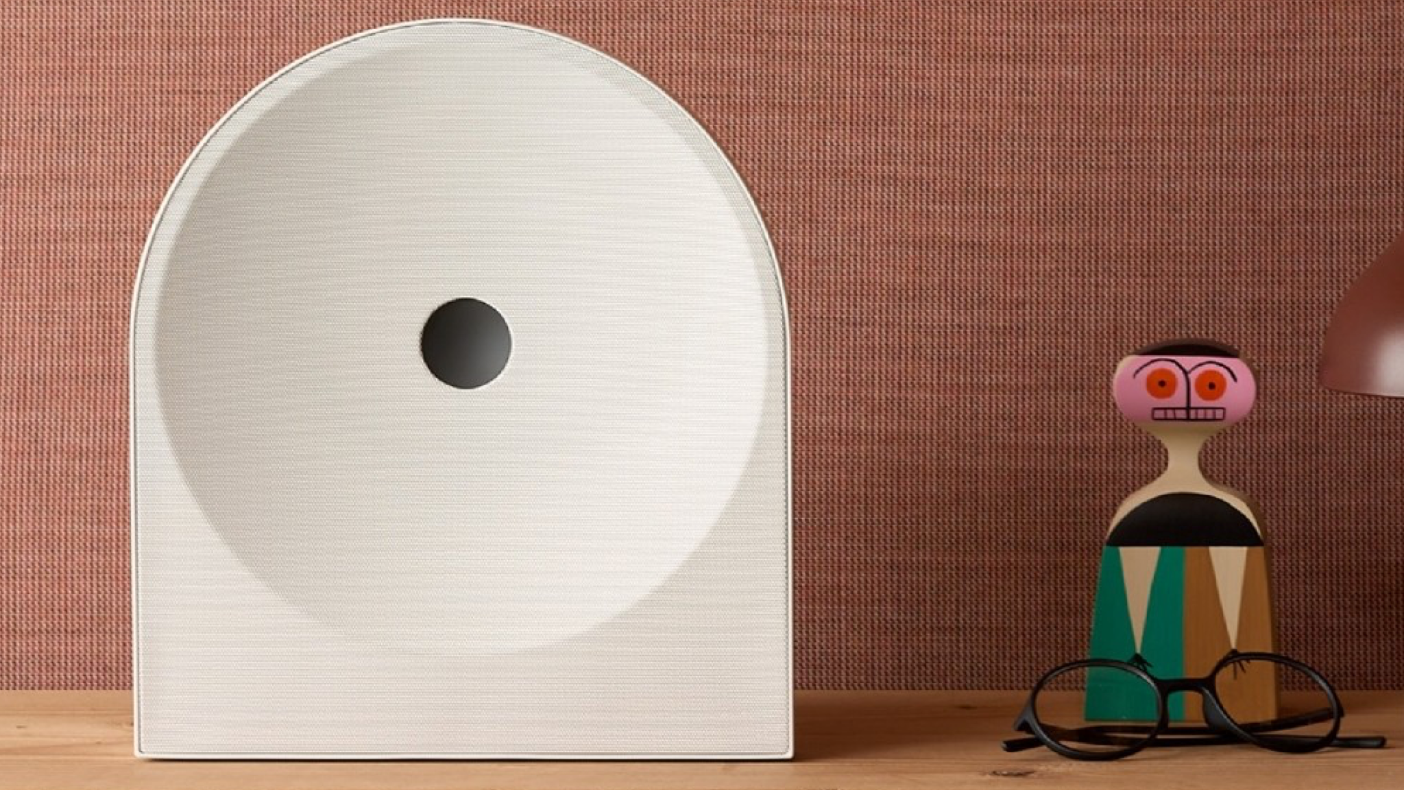 Samsung Music Studio 5 speaker on a wooden surface next to a colourful toy